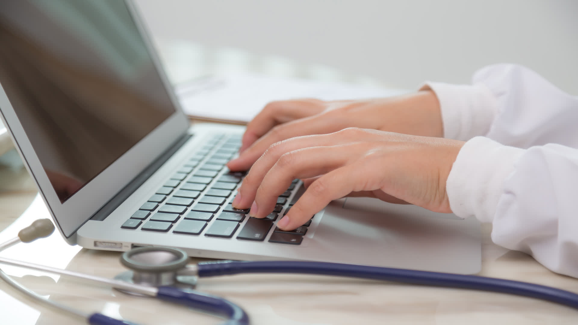 Optometrist typing on laptop
